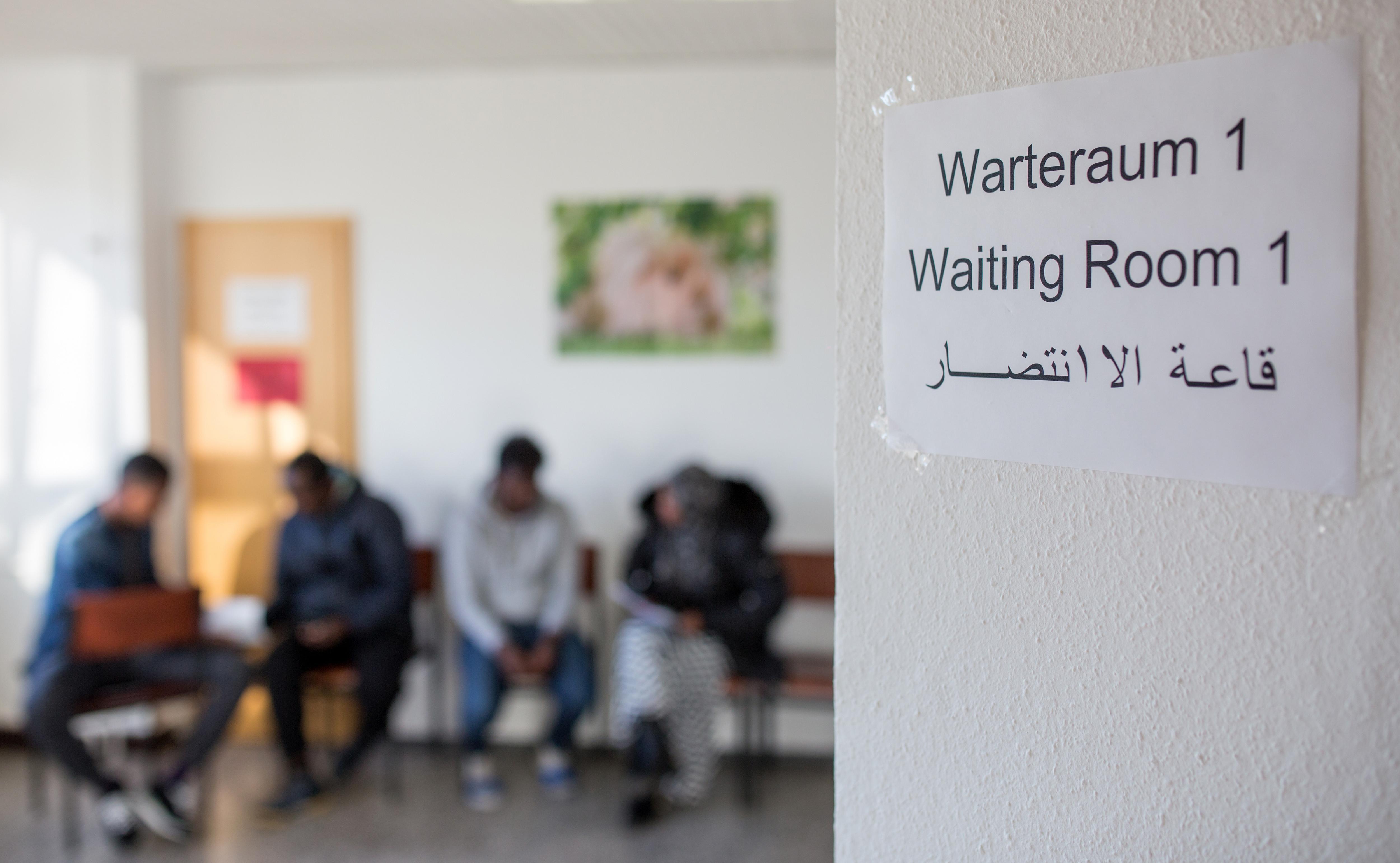 Asylbewerber warten in einem Warteraum.