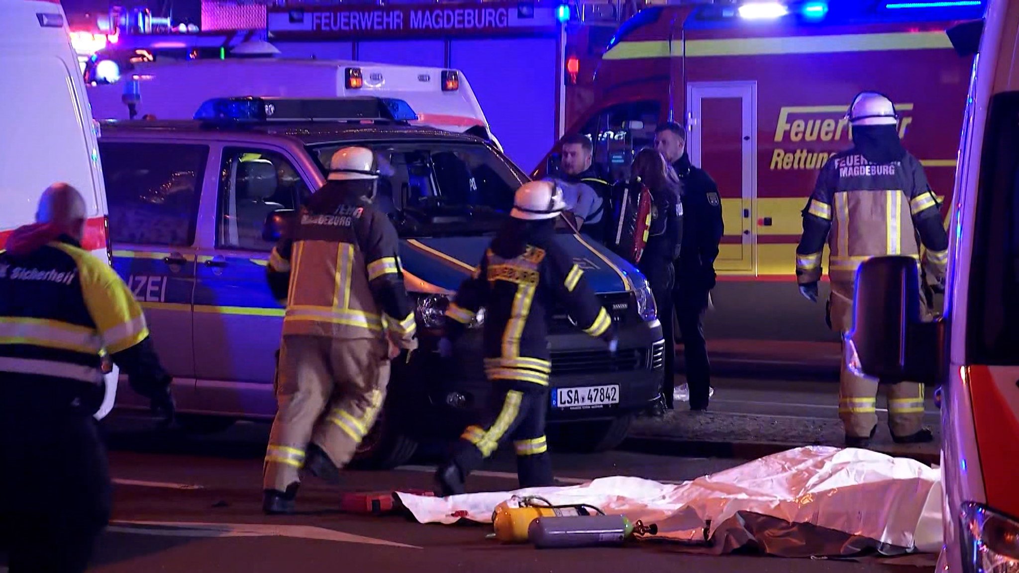 Feuerwehrleute rennen zwischen Einsatzwagen. Bei einem mutmaßlichen Anschlag auf den Weihnachtsmarkt in Magdeburg sind mindestens zwei Menschen gestorben, mindestens 60 sind verletzt.