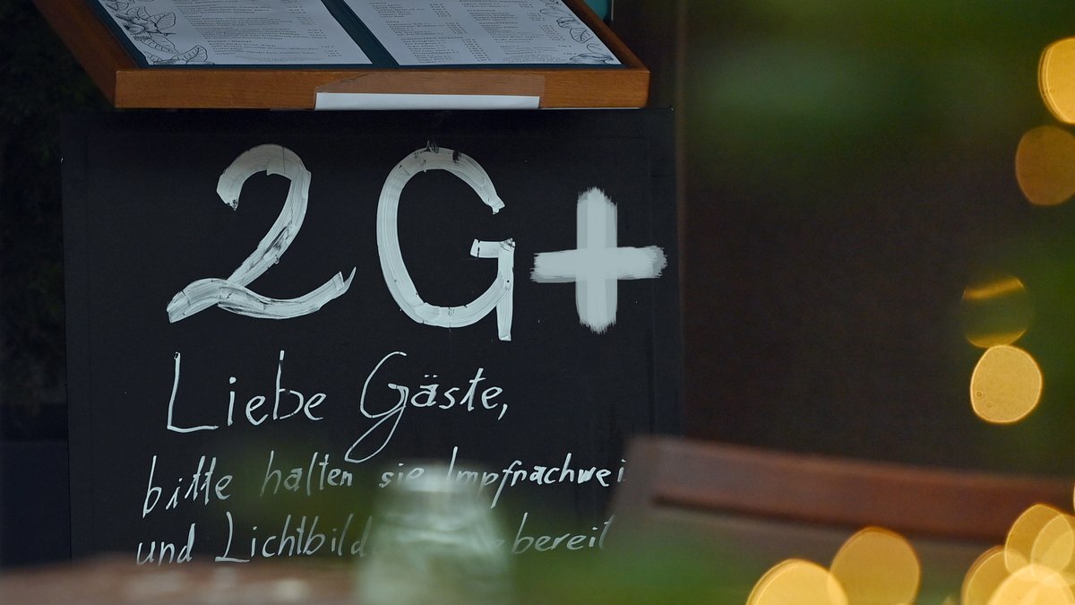 Ein Schild an der Eingangstuer weist auf die 2G+ Regel in einem Restaurant in Muenchen hin.
