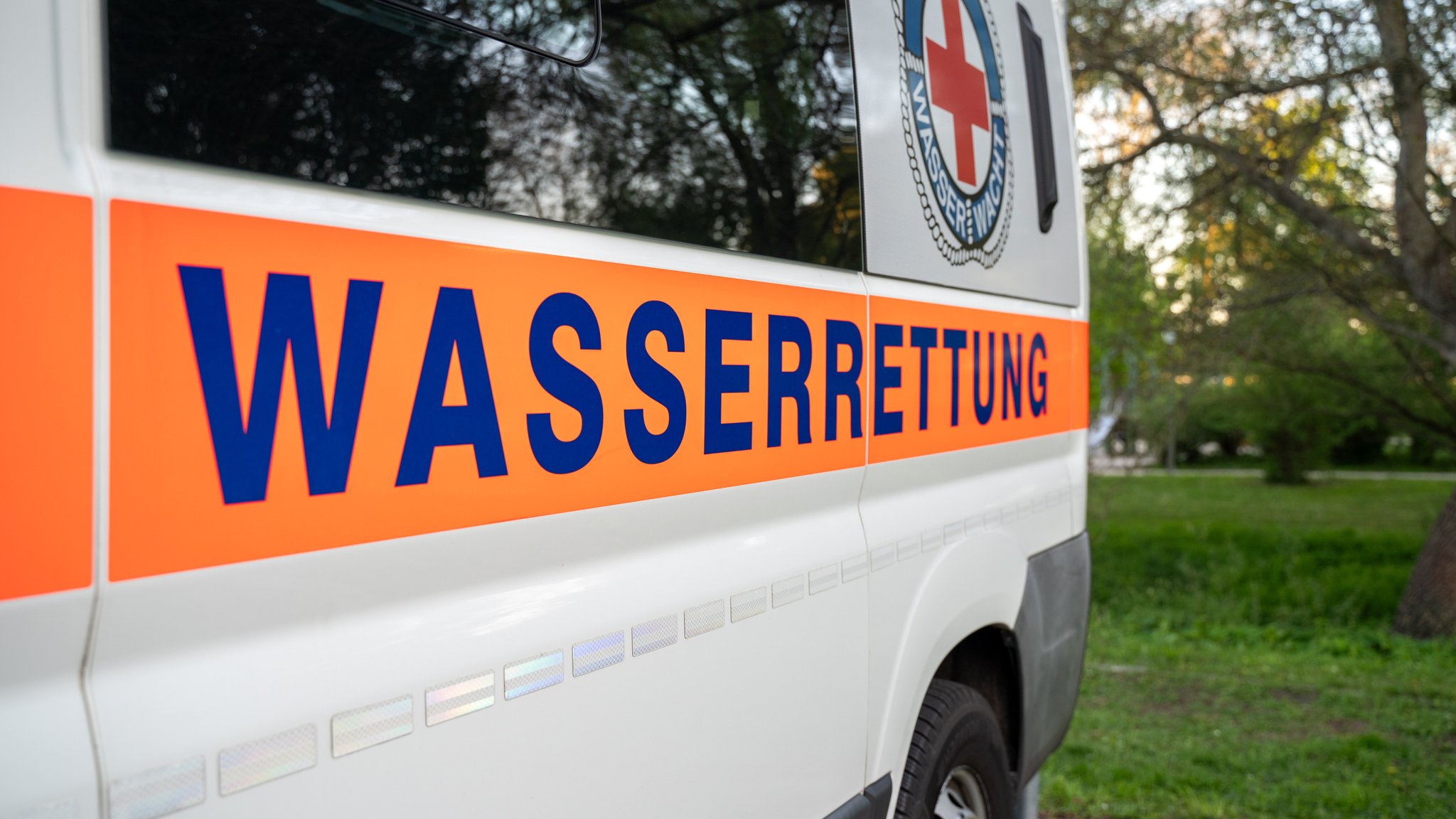 Ein Fahrzeug der Wasserrettung steht am Ufer eines Sees. 