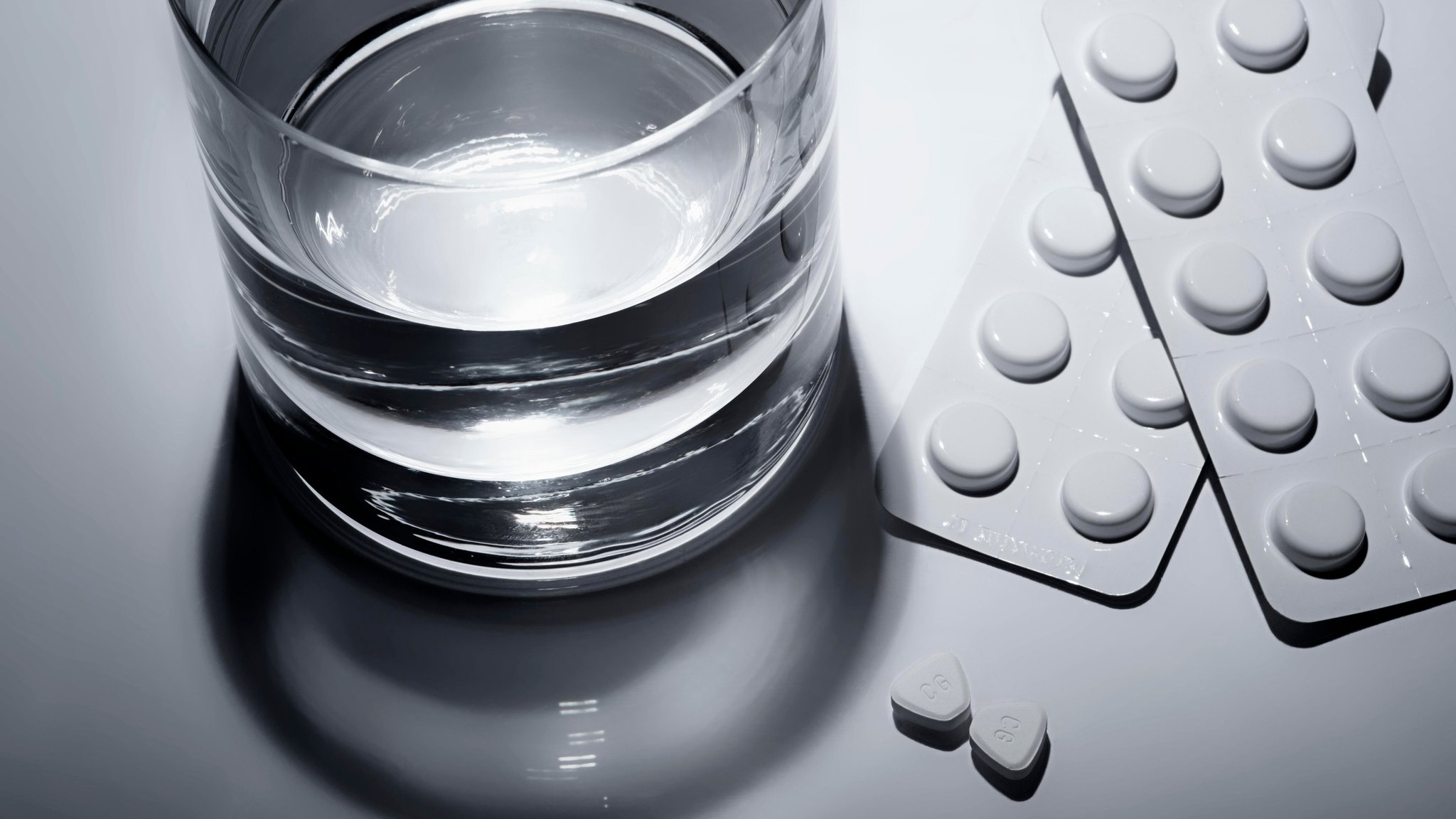 (Symbolbild) Tabletten mit Wasserglas