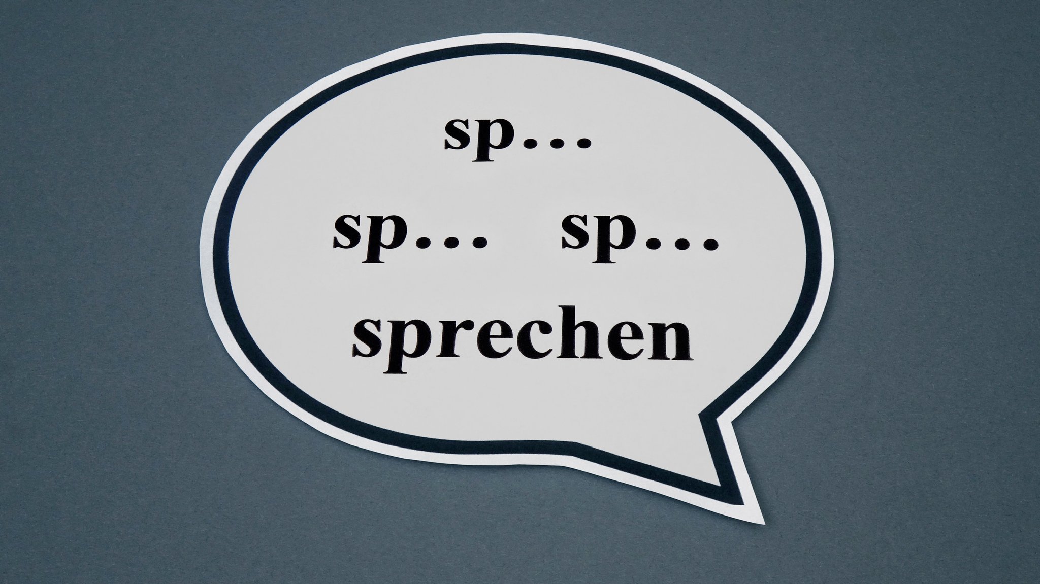 Schwierigkeiten beim Sprechfluss sind besonders in Kindheit und Jugend mit erheblichen Nachteilen verbunden. Im Bild: In einer Sprechblase steht das gestotterte Wort sprechen.