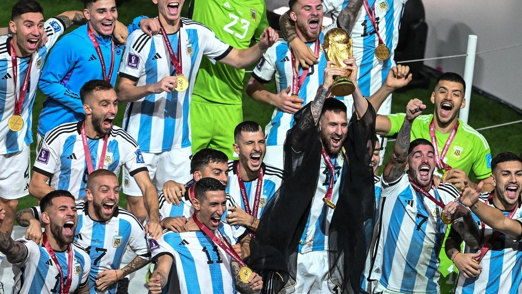 Argentiniens Lionel Messi und seine Mitspieler jubeln mit dem WM-Pokal. 