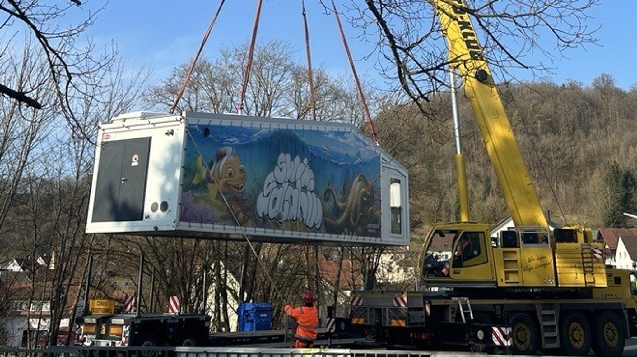 Ein Container wird von einem Kran heruntergelassen.