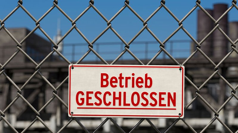 Schild: Betrieb geschlossen an einem Zaun vor einem Werksgelände. | Bild: stock.adobe.com/bluedesign Schild: Betrieb geschlossen an einem Zaun vor einem Werksgelände.