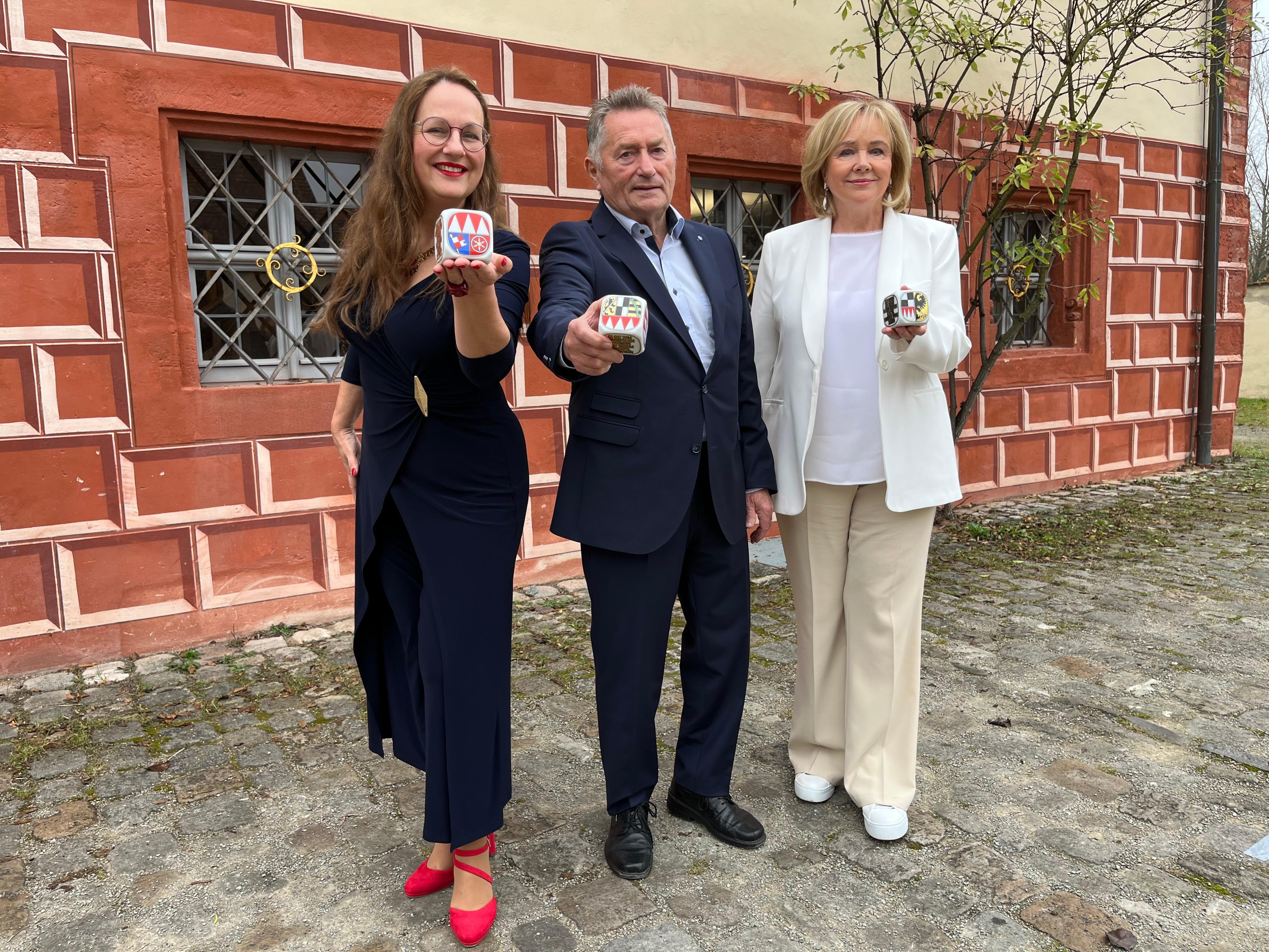 Die Ausgezeichneten halten einen Würfel in der Hand.
