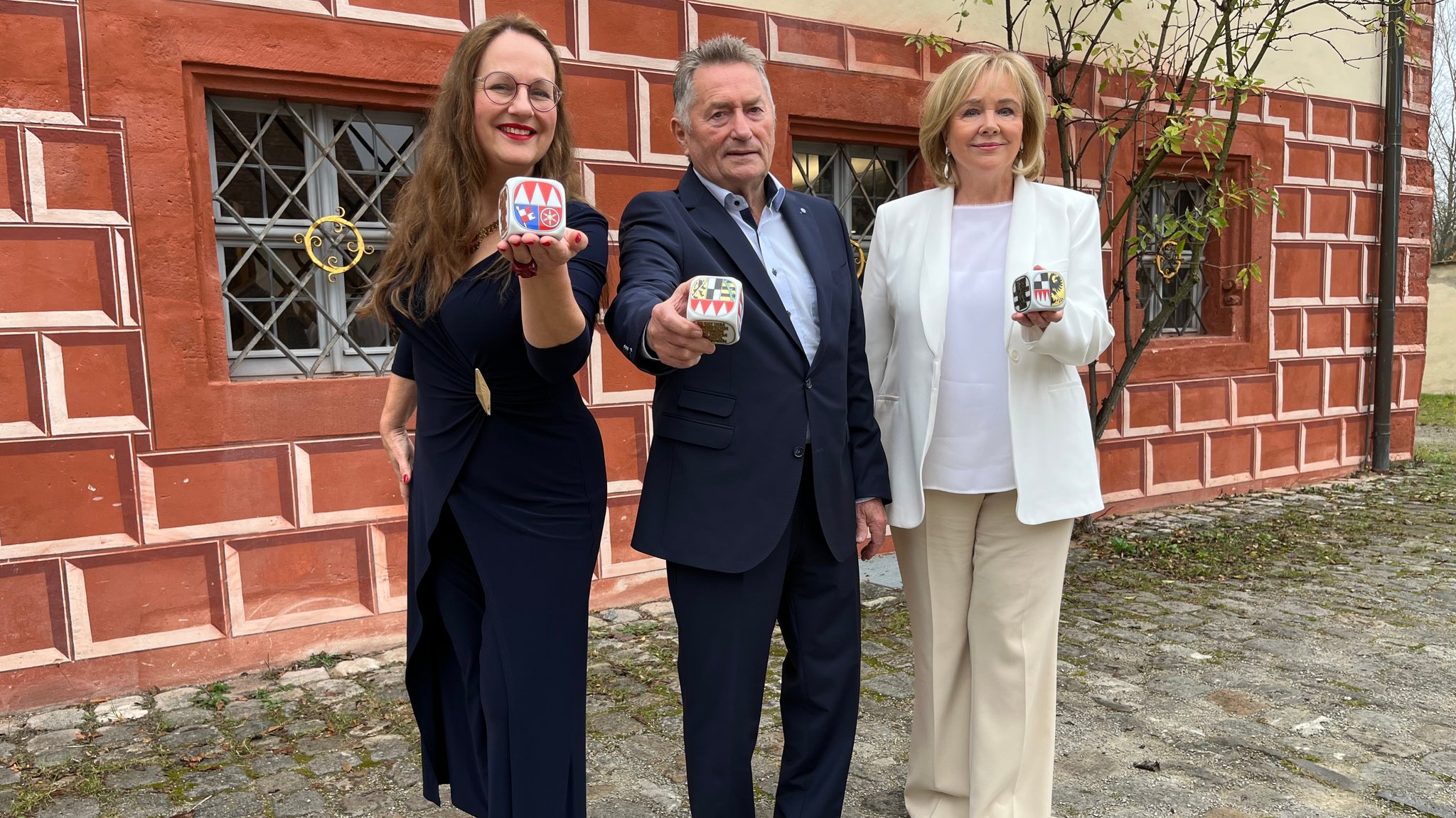 Die Ausgezeichneten halten einen Würfel in der Hand.