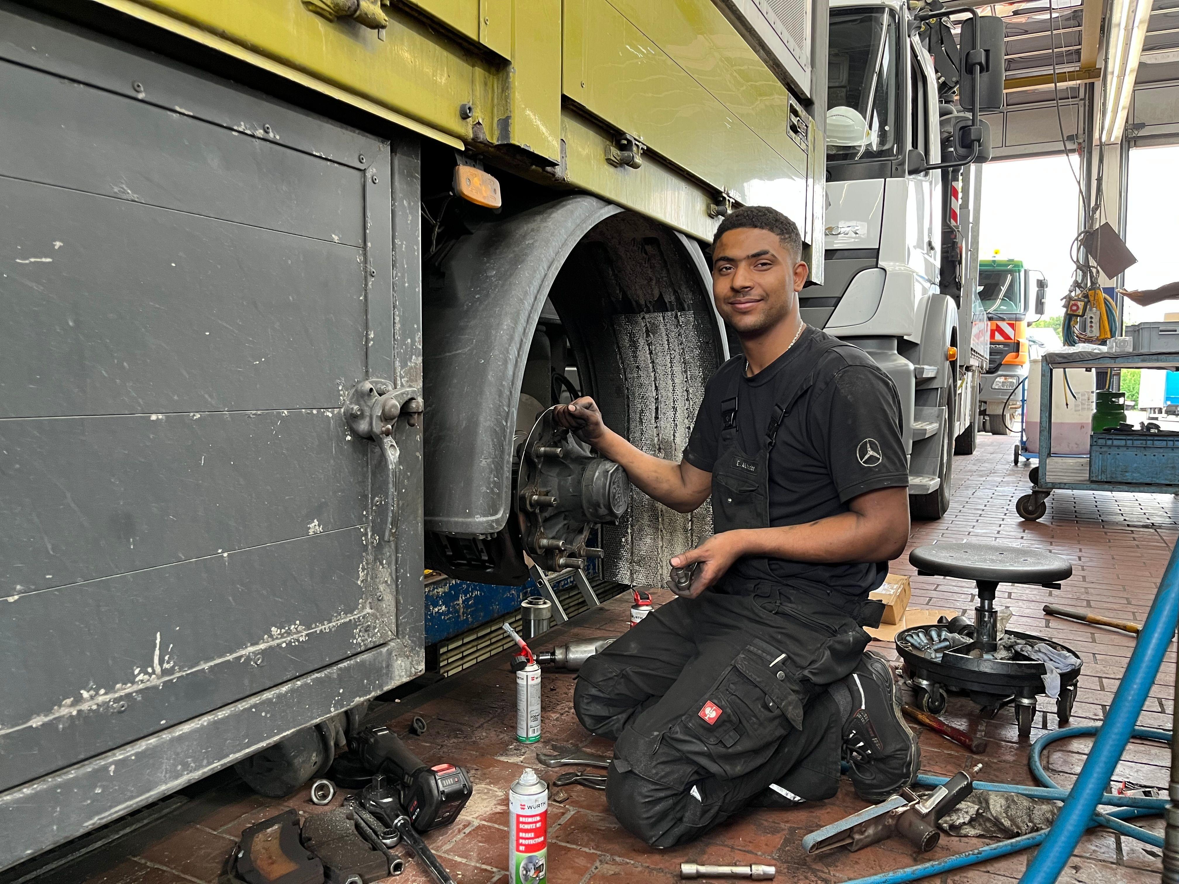 Esam A. kniet in der Werkstatt an einem Lkw.