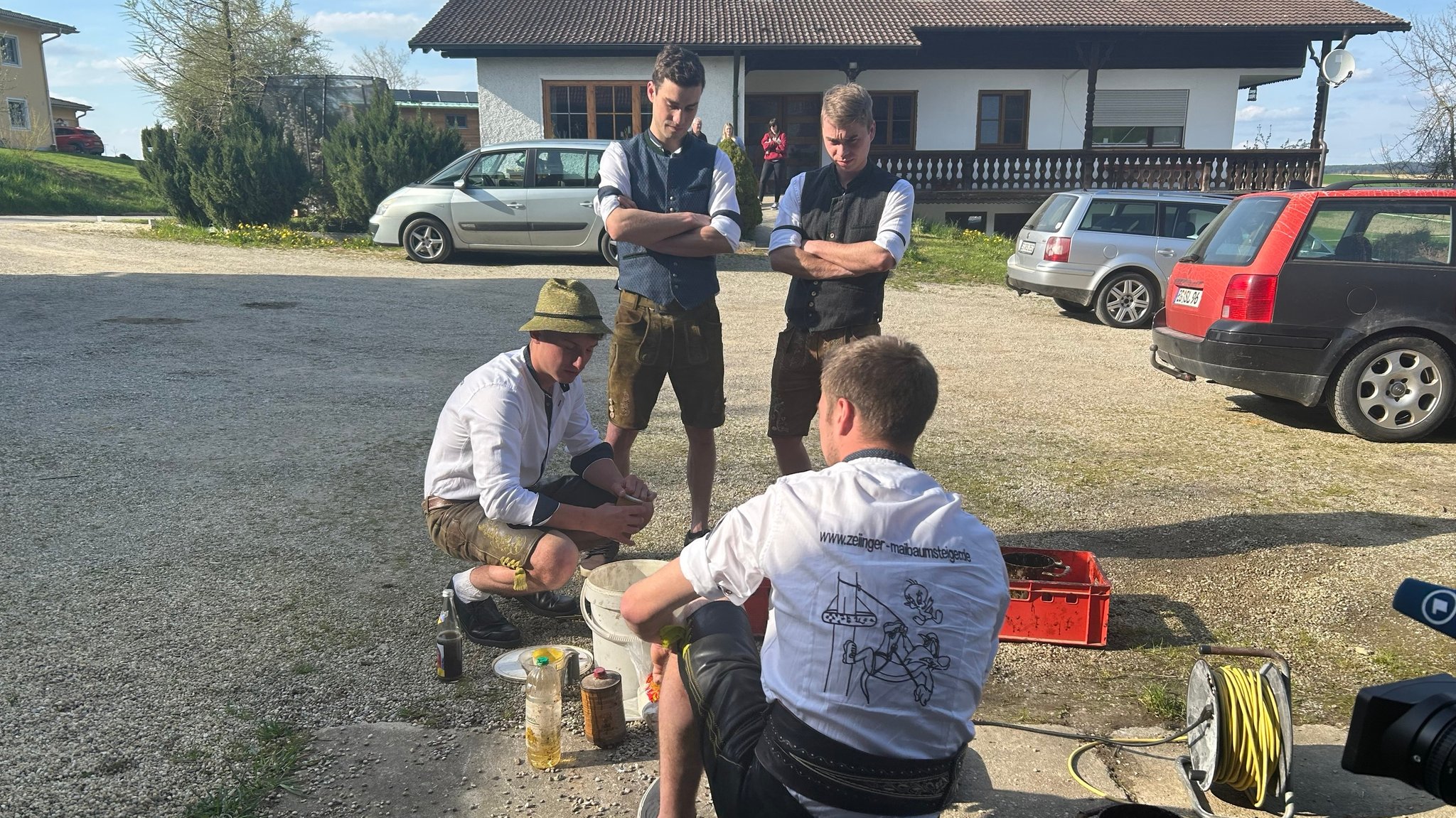 Vier junge Männer sitzen vor einer Elektrokochplatte und stellen eine klebrige Flüssigkeit aus Saupech her, die sie später am Baum sichern wird. 