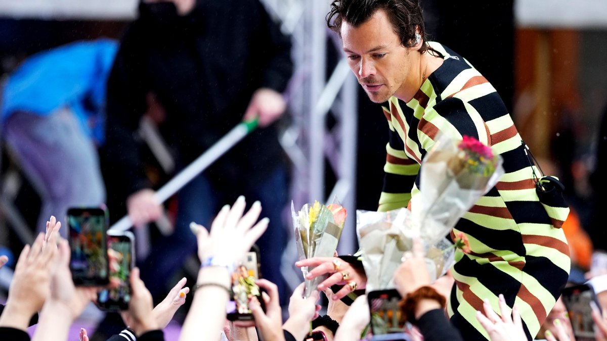 Nach einem Konzert in New York nimmt Harry Styles Blumen von Fans entgegen.