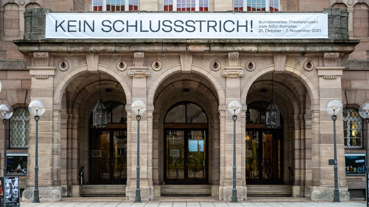 Der Eingang des Staatstheaters Nürnberg mit einem Transparent mit der Aufschrift "Kein Schlussstrich".