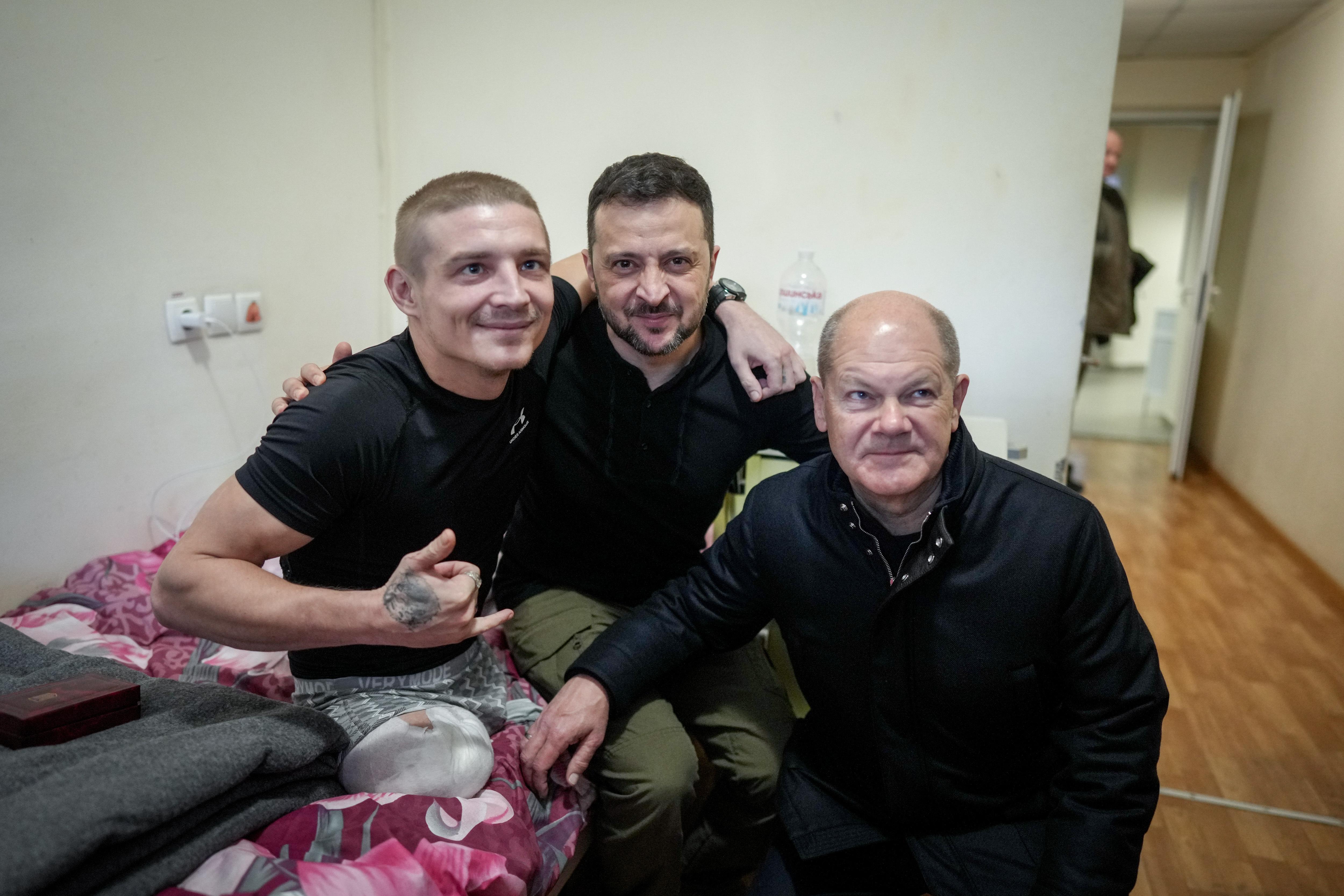 Scholz (r) und Selenskyj (M) lassen sich im Krankenhaus in Kiew mit einem verwundeten Soldaten fotografieren.