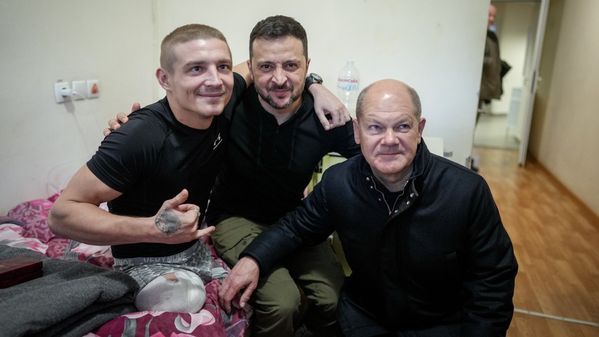 Scholz (r) und Selenskyj (M) lassen sich im Krankenhaus in Kiew mit einem verwundeten Soldaten fotografieren.