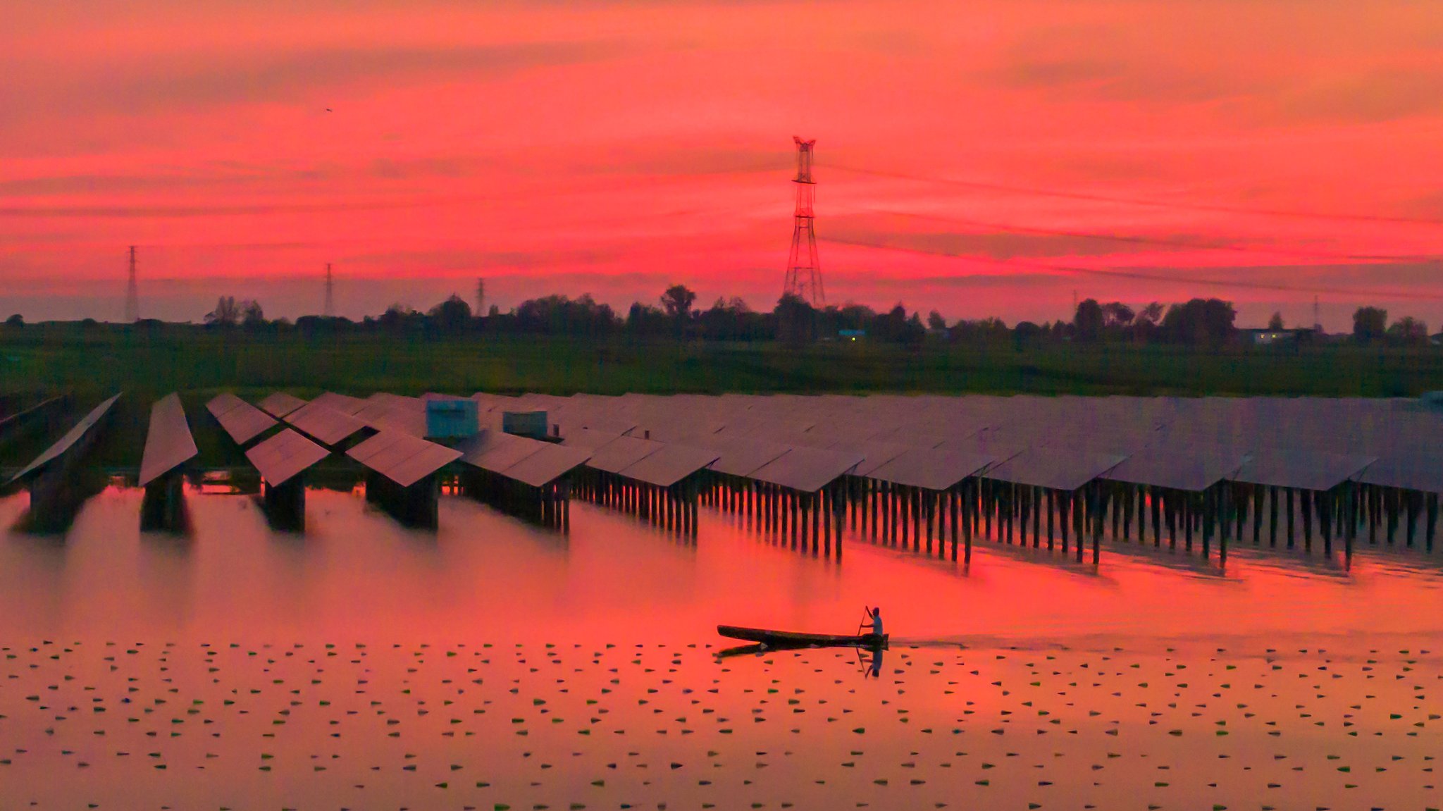 Stausee in China, an dem Photovoltaikanlagen installiert wurden. Im Hintergrund Strommaste.