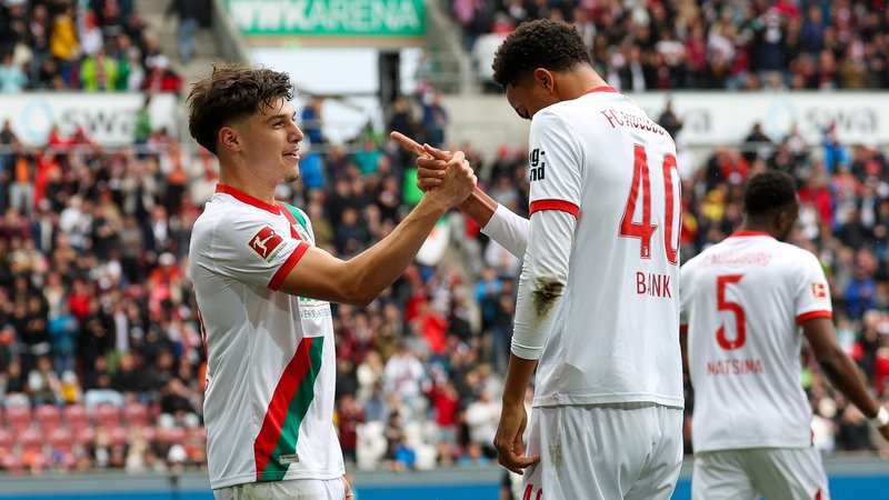 Augsburgs Noahkai Banks (r.) und Mert Kömür beim Torjubel | Bild: picture-alliance/dpa Augsburgs Noahkai Banks (r.) und Mert Kömür beim Torjubel