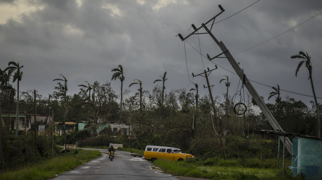 ARCHIV - 27.09.2022, Kuba, Pinar Del Rio: Ein amerikanischer Oldtimer fährt an vom Hurrikan «Ian» umgestürzten Strommasten vorbei. Foto: Ramon Espinosa/AP/dpa +++ dpa-Bildfunk +++