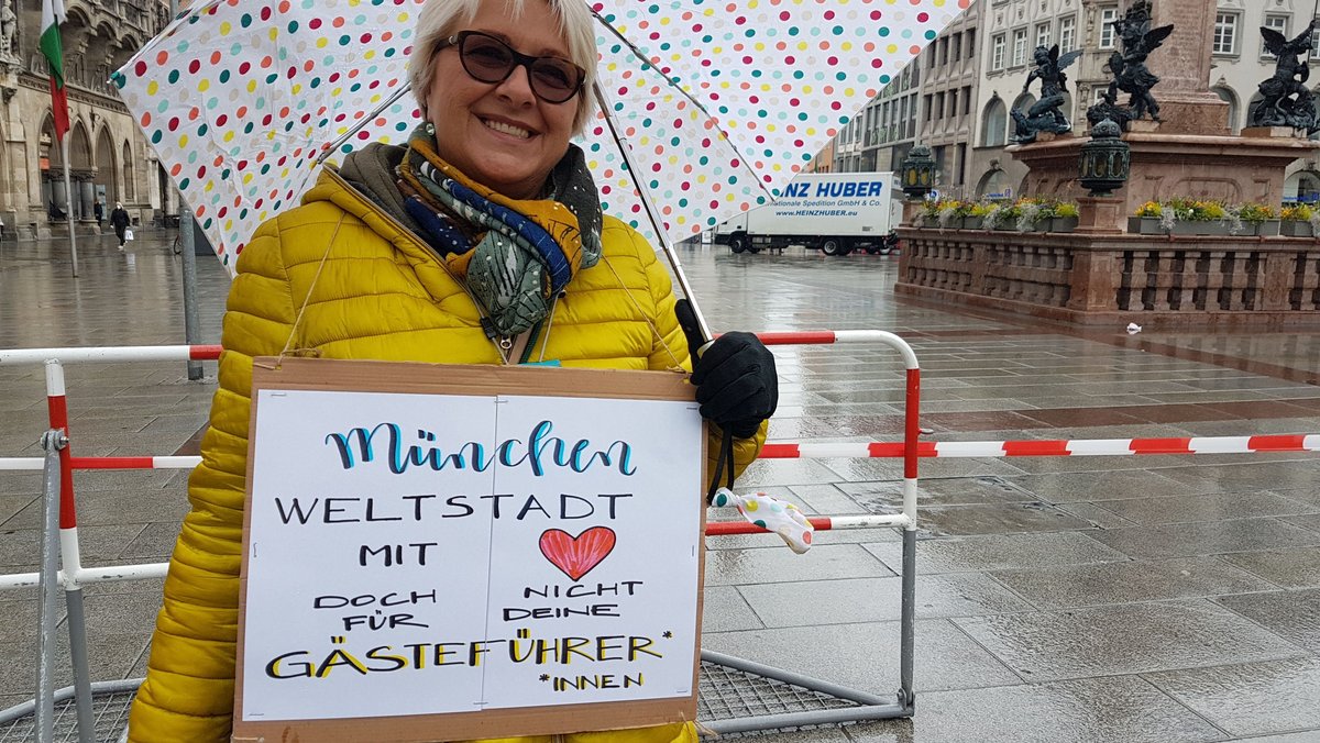 Gästeführerin demonstriert auf Münchner Marienplatz