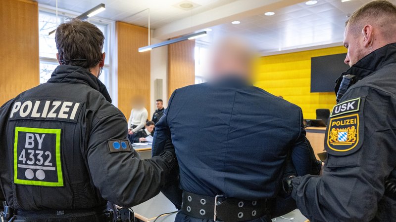 Die angeklagten Männer, die im August 2024 aus dem BKH in Straubing geflohen waren, werden von Polizisten in den Verhandlungssaal des Landgerichts Regensburg geführt. | Bild: pa/dpa/Armin Weigel Die angeklagten Männer, die im August 2024 aus dem BKH in Straubing geflohen waren, werden von Polizisten in den Verhandlungssaal des Landgerichts Regensburg geführt.