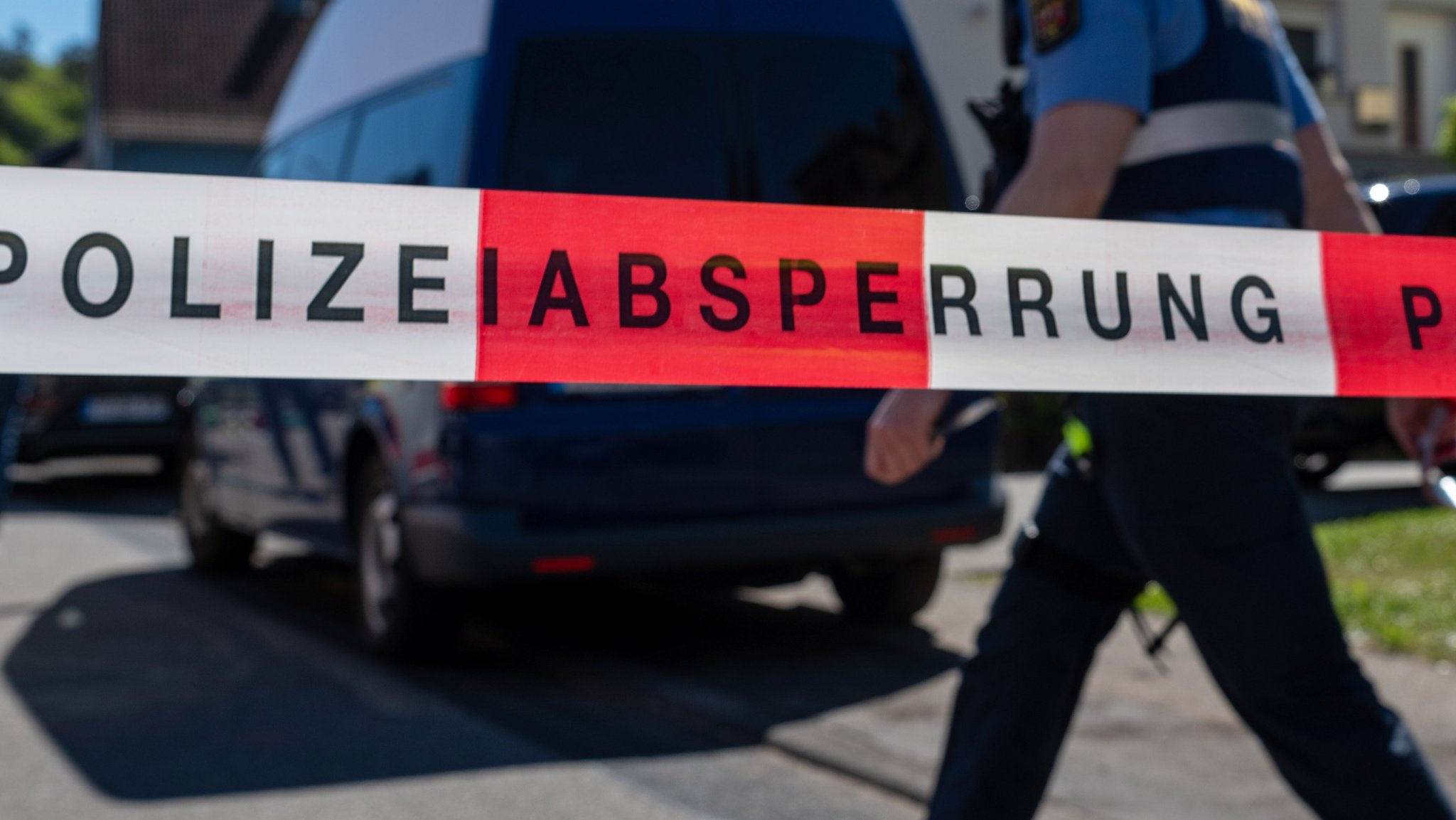 (Symbolbild) Ein Polizist geht an einem Absperrband eines Tatorts vorbei. | Bild: pa/dpa | Harald Tittel (Symbolbild) Ein Polizist geht an einem Absperrband eines Tatorts vorbei.