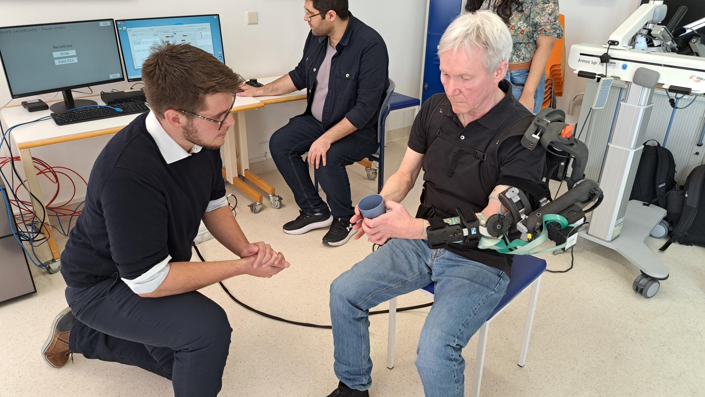 Wolfgang Korisanski testet die hybride Neuroprothese. Das intelligente System trainiert mithilfe eines Exoskeletts und KI seinen gelähmten Arm.