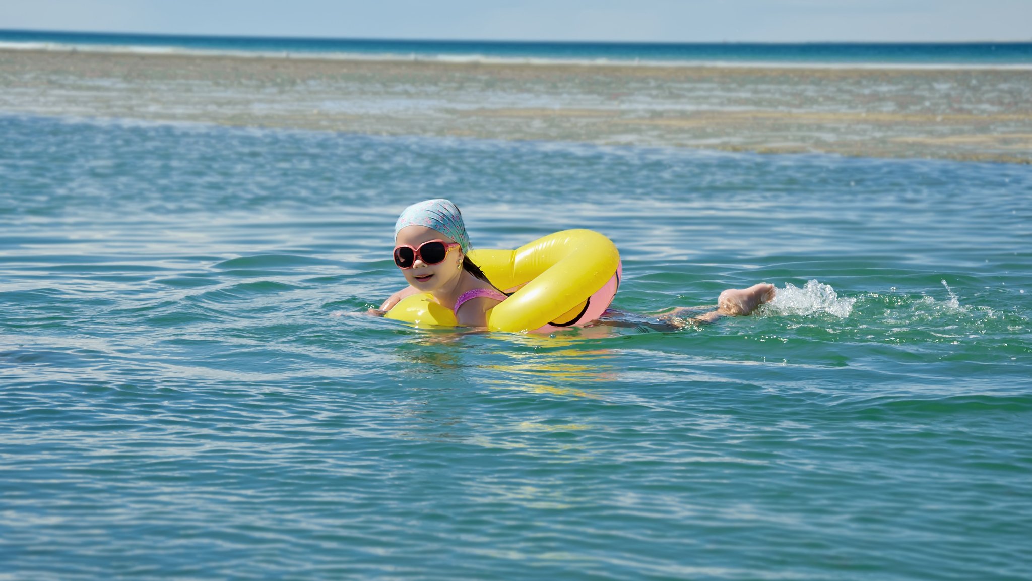 Kind mit Schwimmring im Meer