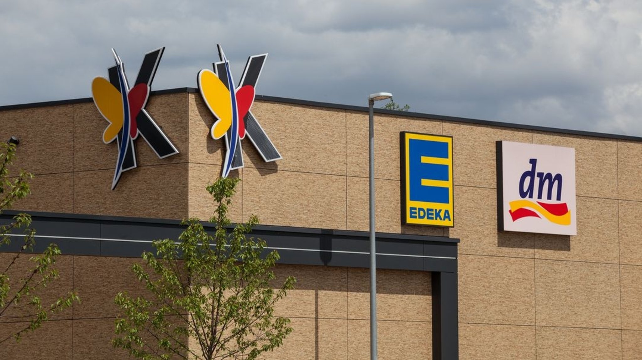 Markenschilder von Edeka und dm in einem Gewerbegebiet.