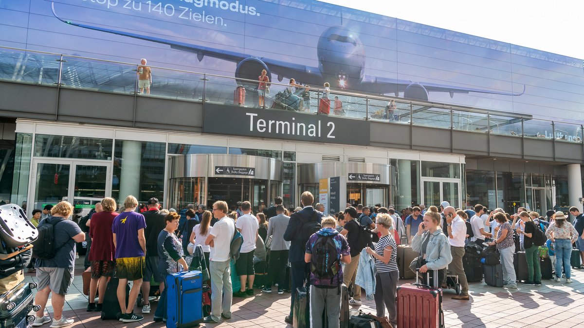 Fluggäste stehen am 27. August vor dem verschlossenen Eingang zum Terminal 2 am Münchner Flughafen.
