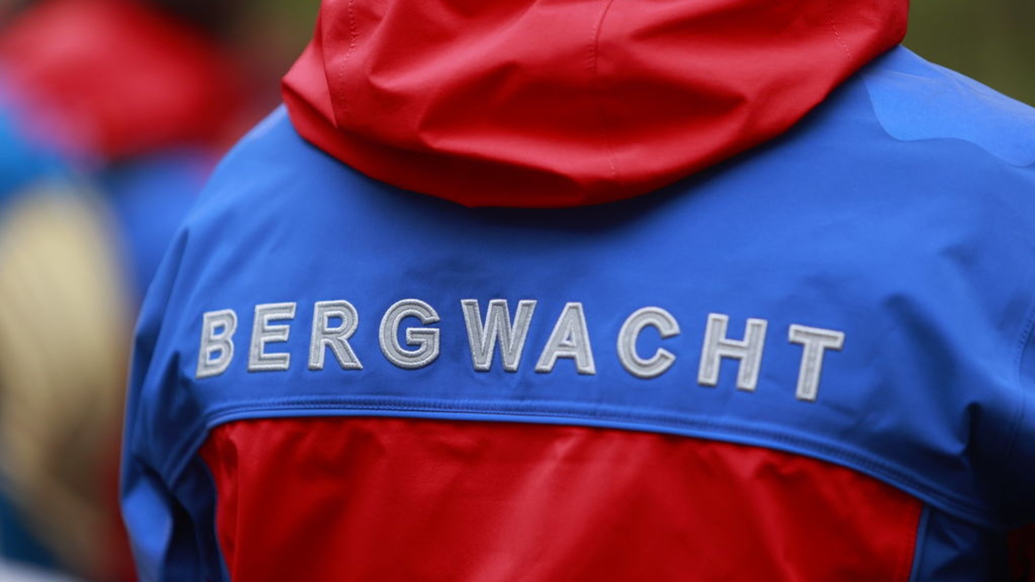 Der Schriftzug Bergwacht steht auf der Einsatzkleidung eines Bergwachtmitgliedes. | Bild: dpa-Bildfunk/Matthias Bein Der Schriftzug Bergwacht steht auf der Einsatzkleidung eines Bergwachtmitgliedes.