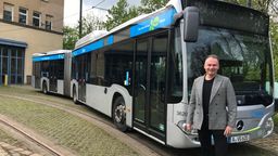 Stadtwerke-Betriebsleiter Klaus Röder auf dem bisherigen Busbetriebshof vor dem Testmodell eines E-Busses.  | Bild:BR/ Barbara Leinfelder 