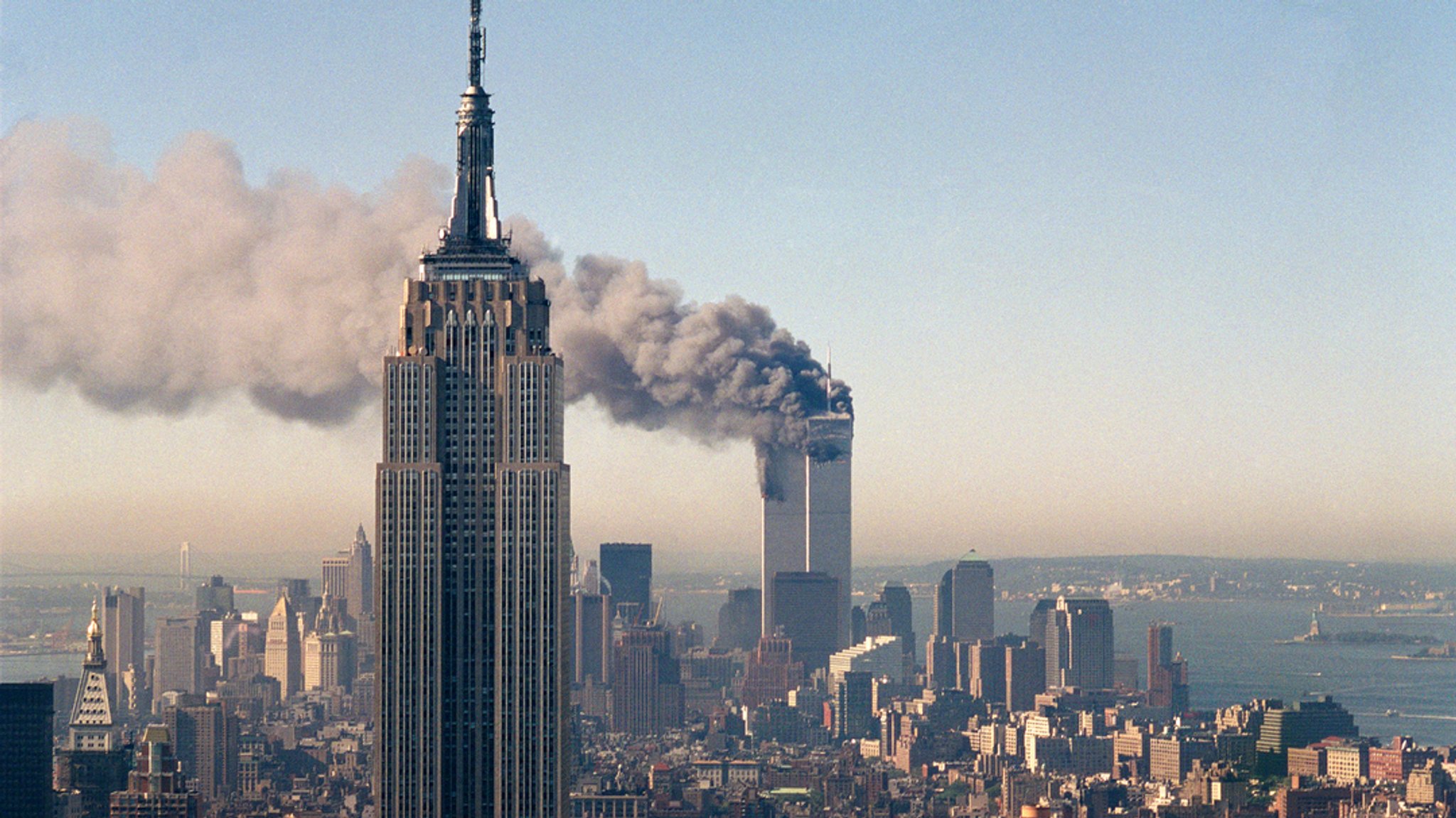 11. September 2001, USA, New York: Die Zwillingstürme des World Trade Centers brennen hinter dem Empire State Building.