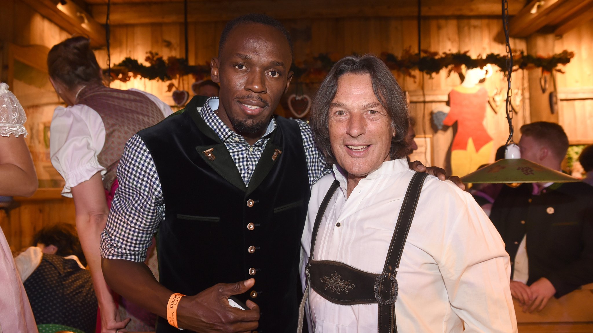 Der jamaikanische Sprinter und Olympiateilnehmer Usain Bolt (l) und der Ex-Bayern Arzt Hans-Wilhelm Müller-Wohlfahrt sind am 30.09.2016 in München (Bayern) auf dem Oktoberfest im Weinzelt zu sehen. 