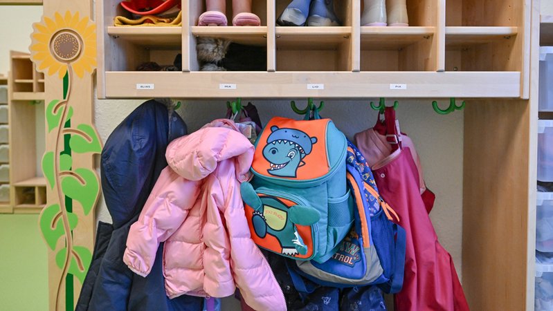 Symbolbild: Kleidung von Kindern hängt in einer Kita