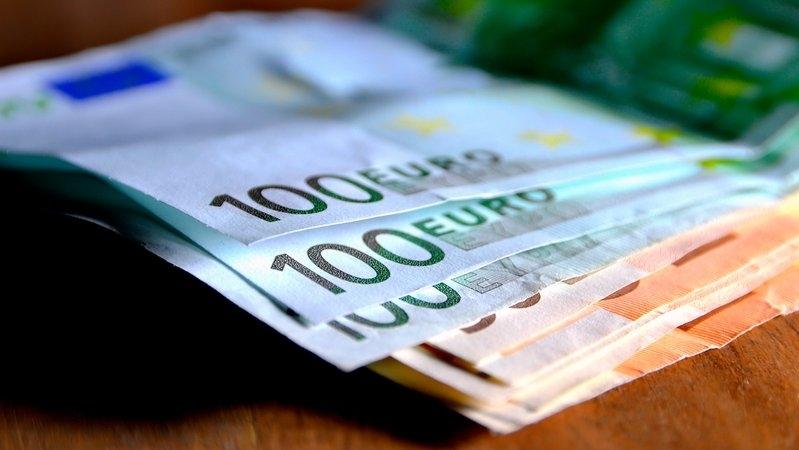 Mehrere Geldscheine liegen auf einem Tisch (Symbolbild).