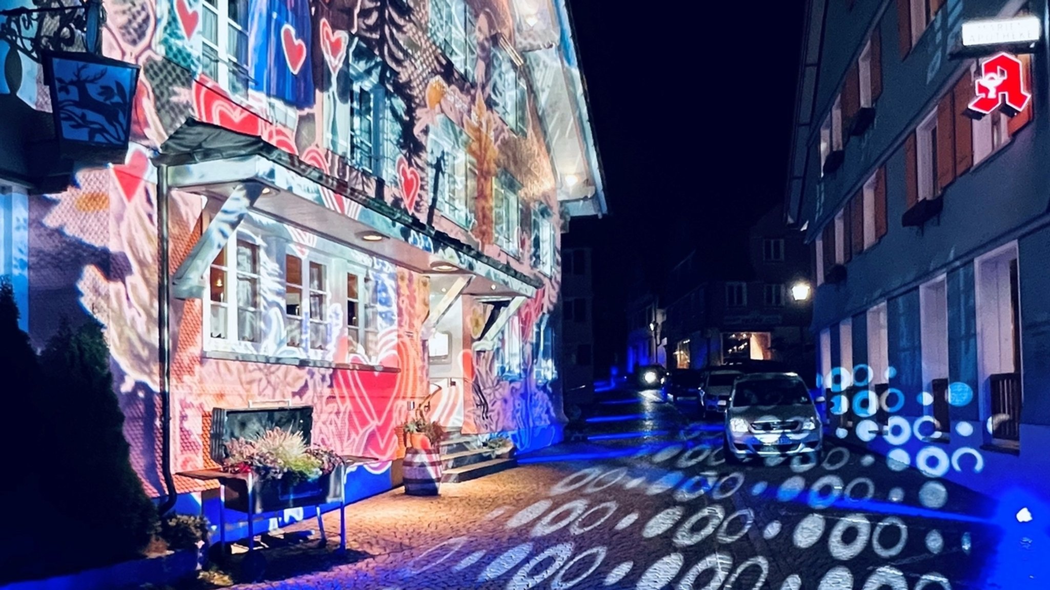 Mit alpenländischen Motiven angestrahltes Schindel-Haus  bei der "Lichterwelt" in Scheidegg.