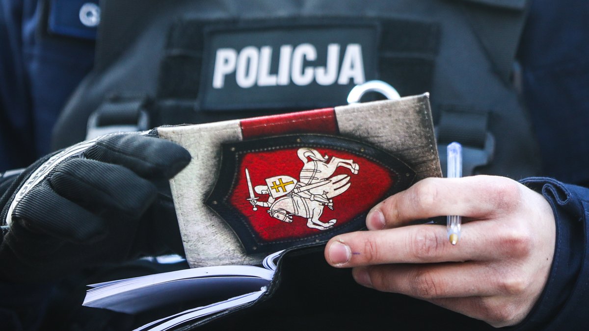 Ein polnischer Polizist prüft in Krakau einen Ausweis.