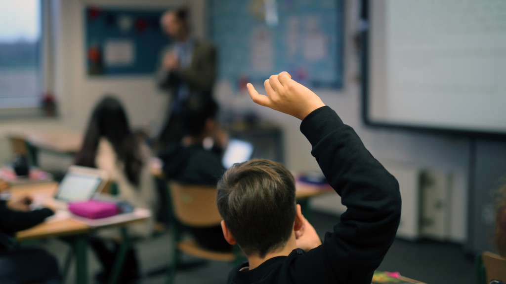 Schule (Symbolbild): Ein Schüler hebt im Unterricht seine Hand hoch.
