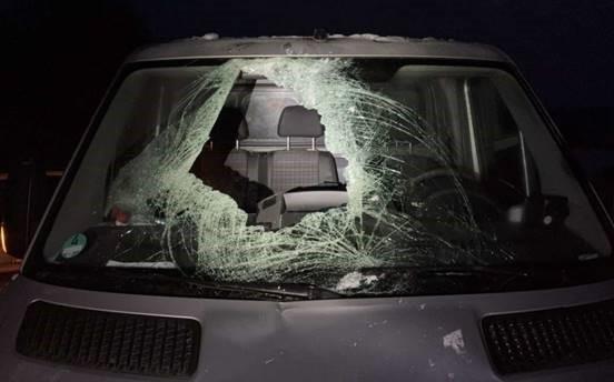 Eine zersplitterte Windschutzscheibe mit einem großen Loch. 