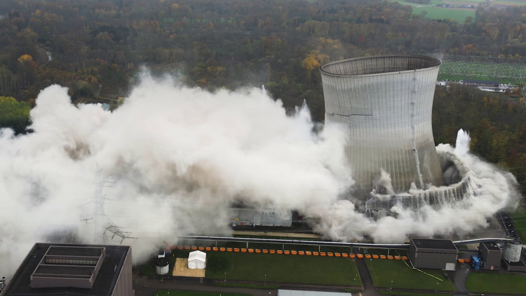 Die gigantischen Kühltürme des stillgelegten Kernkraftwerks in Gundremmingen versinken in Staubwolken.