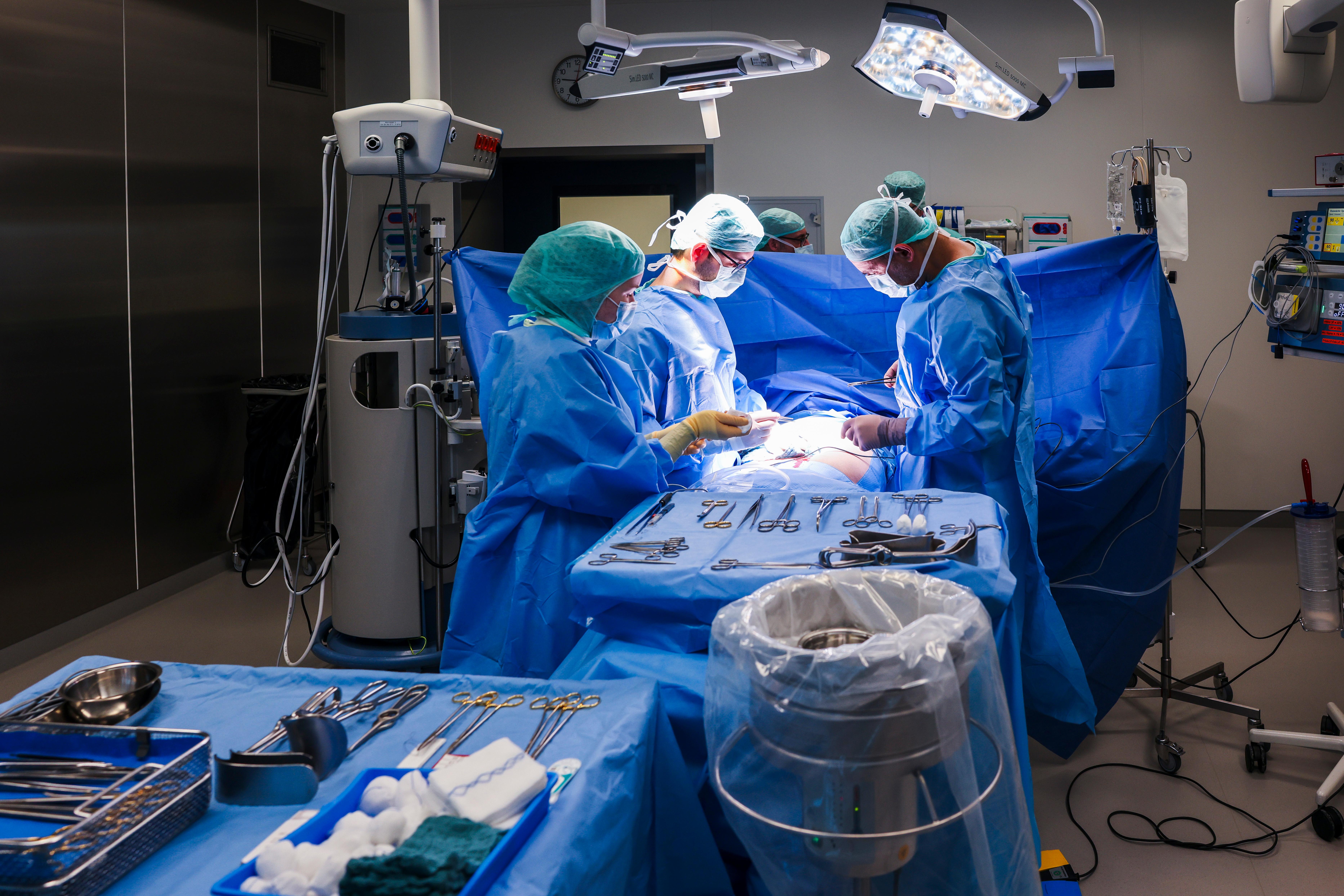 Ärzte und OP-Personal stehen während einer Operation am OP-Tisch