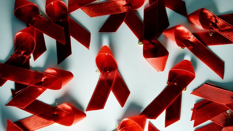 Rote Aids Schleifen liegen auf einem Tisch. 