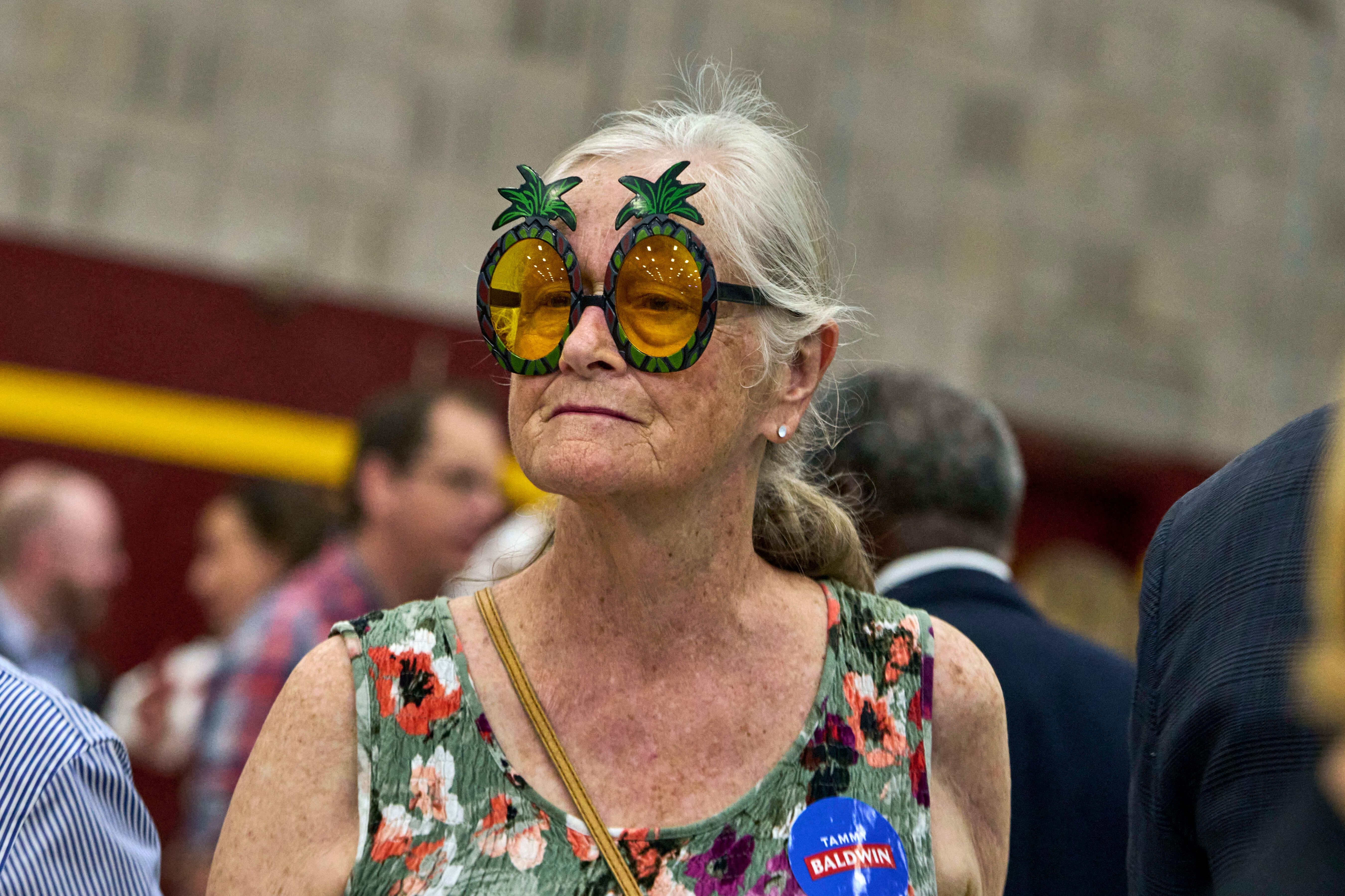 Eine Unterstützerin von Kamala Harris trägt eine Kokospalmen-Brille bei einer Wahlkampfveranstaltung.