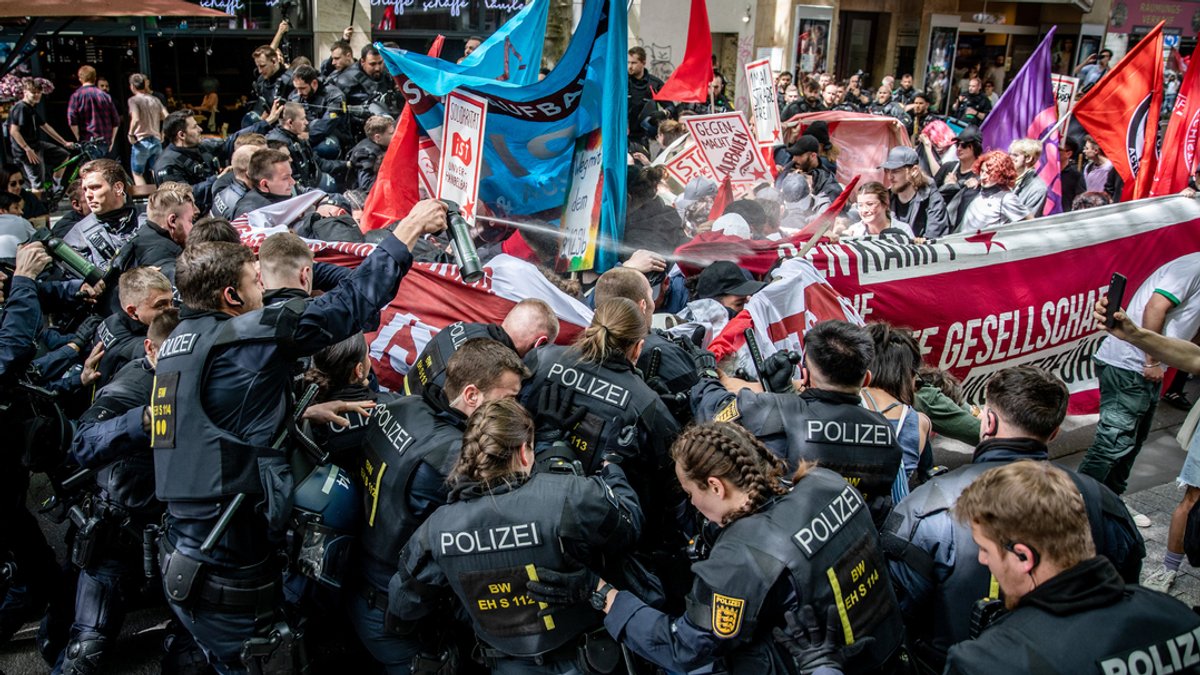01.05.2024, Stuttgart: Polizisten stoßen während der 1. Mai Demo in der Stuttgarter Innenstadt mit Demonstrationsteilnehmern zusammen. 