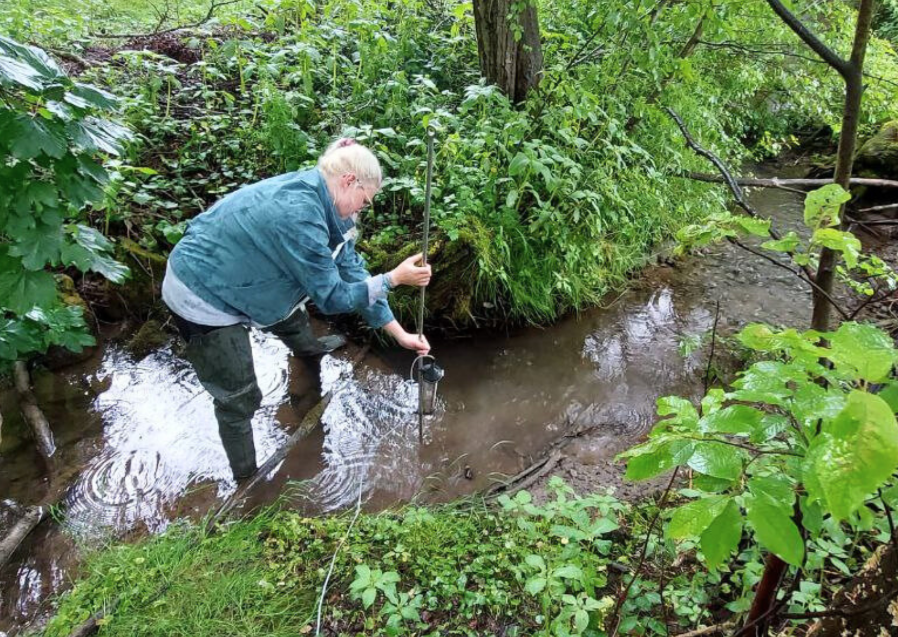 LBV-Projektleiterin Raphaela Karl installiert den automatischen Probenehmer in einem kleinen Bach im Münchner Umland