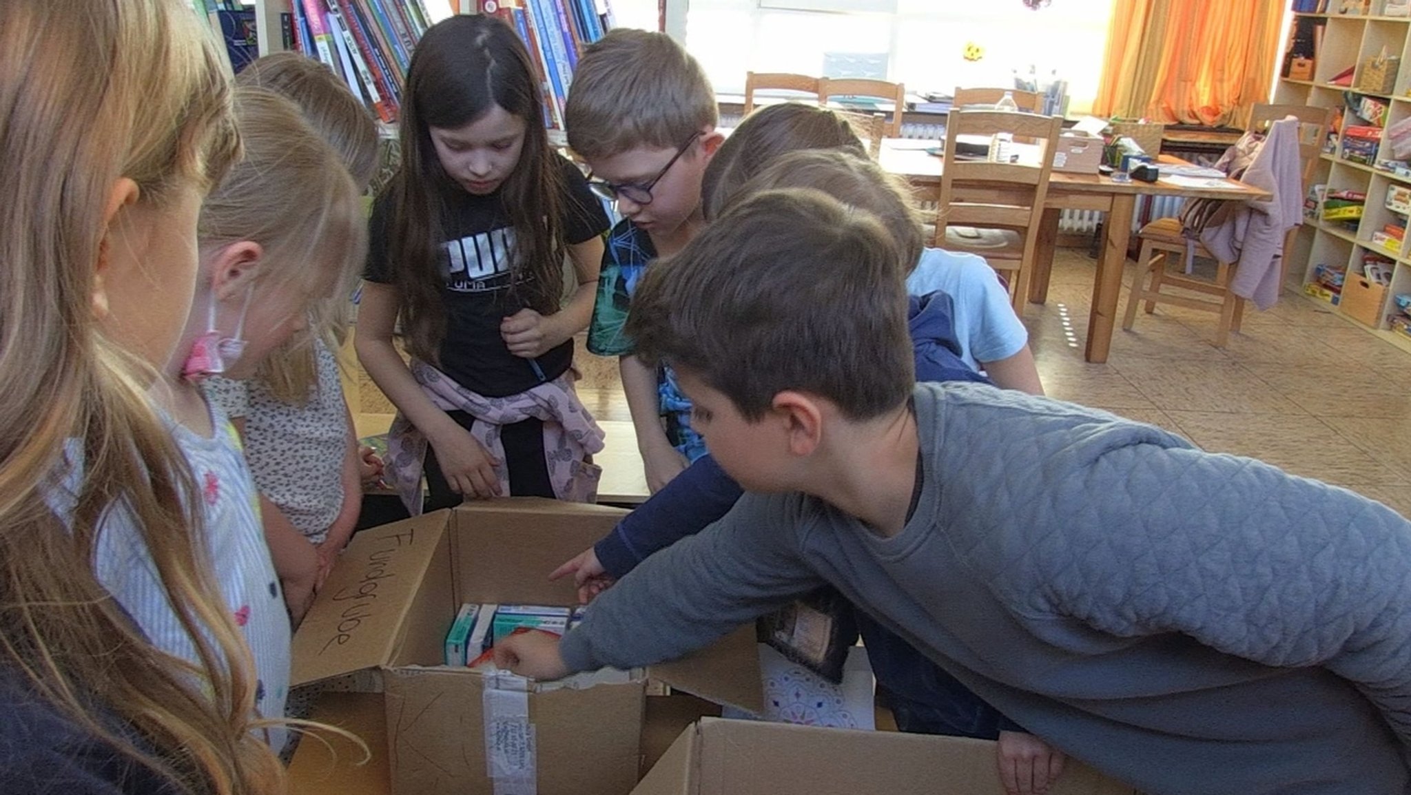 Kinder in der Schulkindbetreuung direkt neben der Notunterkunft sammeln für die geflüchteten Kinder dort.