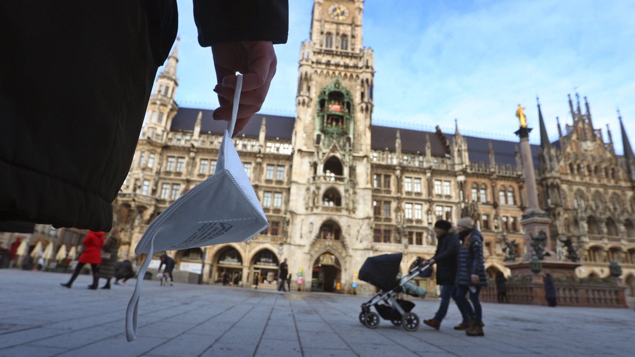 Eine Frau hält auf dem Marienplatz eine FFP2 Maske.