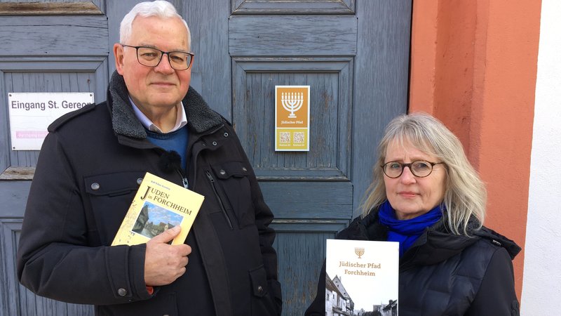 Historiker Rolf Kießling und Pfalzmuseumsleiterin Susanne Fischer halten jeweils ein Buch in der Hand.