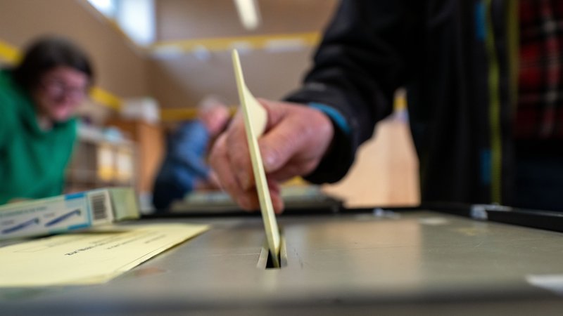 Ein Mann wirft einen ausgefüllten Wahlzettel in eine Wahlurne. In Bayern werden am Sonntag bei den Gemeinde- und Landkreiswahlen im Freistaat fast 40.000 Mandatsträger neu gewählt. | Bild: picture alliance/dpa | Pia Bayer Ein Mann wirft einen ausgefüllten Wahlzettel in eine Wahlurne. In Bayern werden am Sonntag bei den Gemeinde- und Landkreiswahlen im Freistaat fast 40.000 Mandatsträger neu gewählt.
