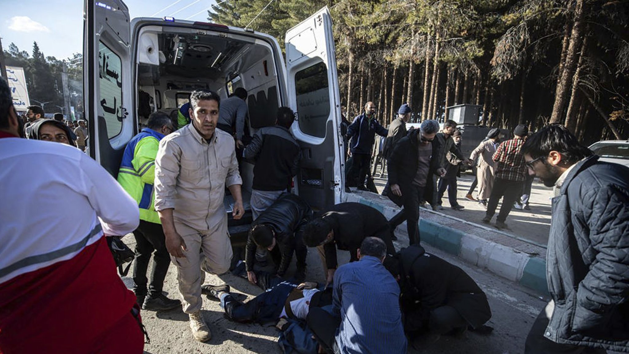 03.01.2024, Iran, Kerman: Menschen und Rettungskräfte versorgen Verletzte nach Explosionen. 