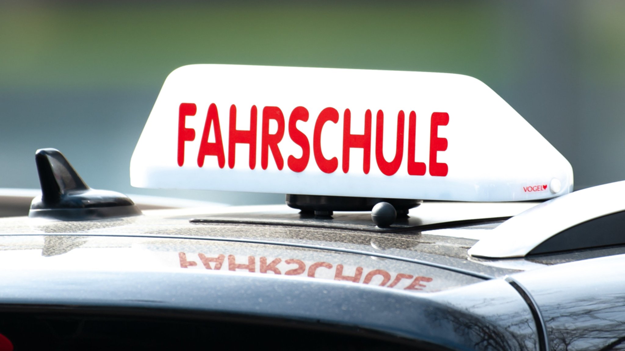 Ein Fahrschul-Schild auf einem Auto.