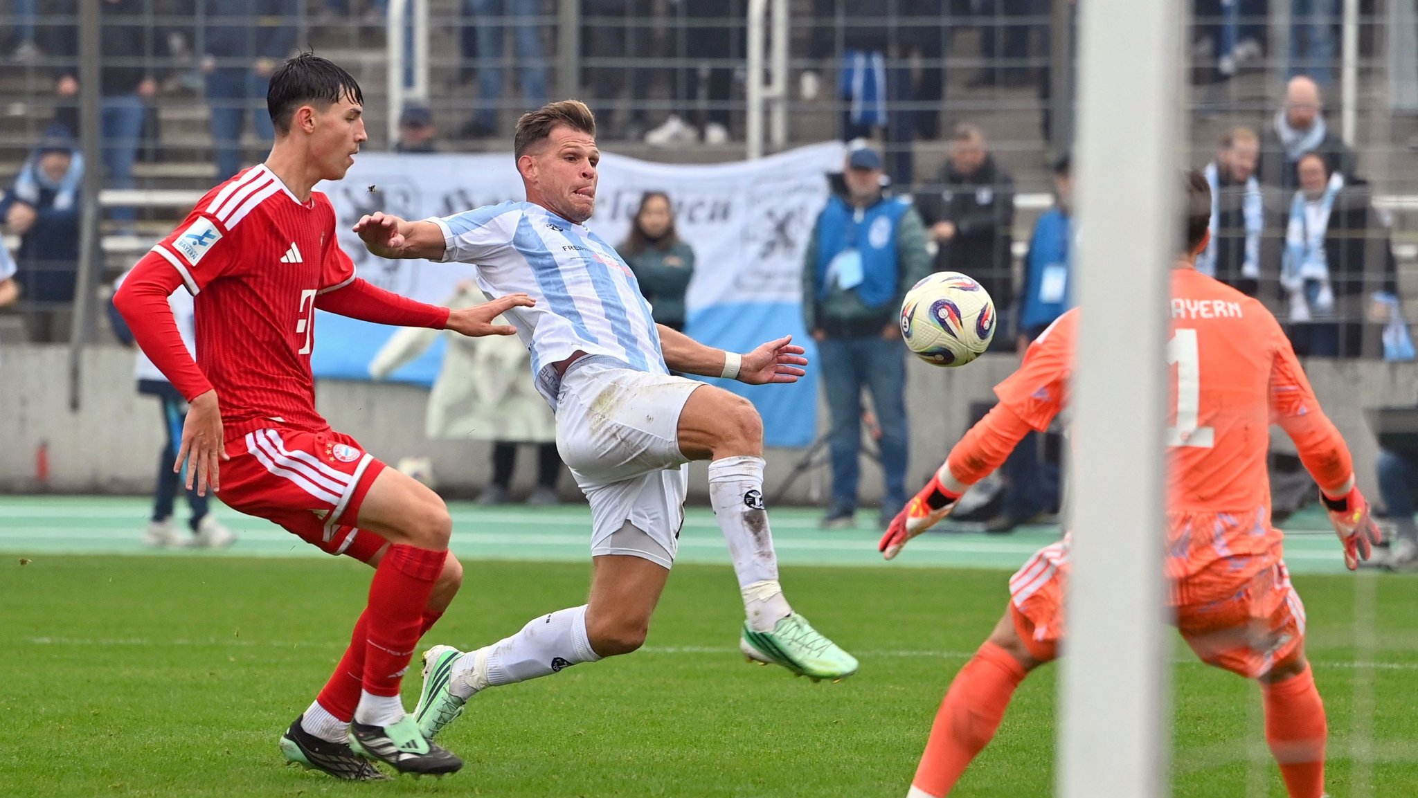 18.10.2026, Bayern, München: Fußball, Männer: Regionalliga Bayern, TSV 1860 München - Bayern München II, Fußball, Stadion an der Grünwalder Straße, Florian Niederlechner (M, 1860 München) versucht neben FIlip Pavic (l, Bayern München II) und Torwart Jannis Baertl (Bayern München II) an den Ball zu kommen. Foto: Frank Hoermann / SVEN SIMON/dpa +++ dpa-Bildfunk +++